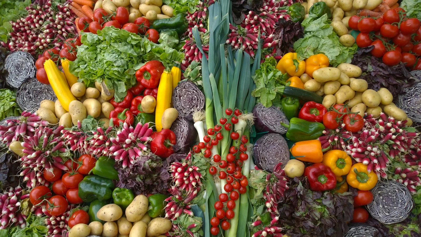 Un raccolto ricco di pomodori, peperoni, cavoli e ortaggi dai colori vivaci